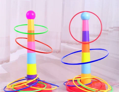 Los niños lanzan juguetes apilados con virola de juego circular